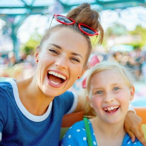 Mother and child smiling after comprehensive family dental care