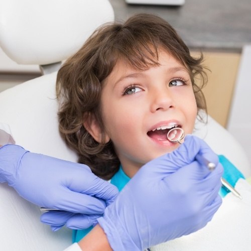 Child receiving dental checkup and teeth cleaning for kids