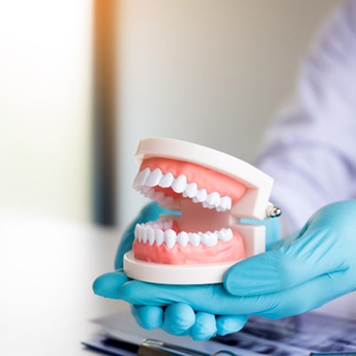 dentist holding false teeth 