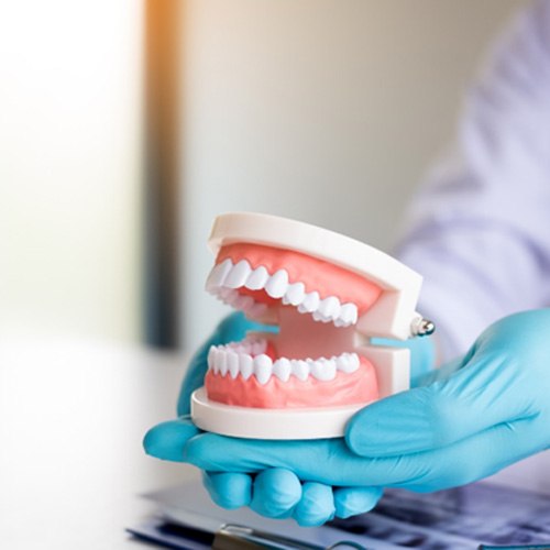 dentist holding false teeth