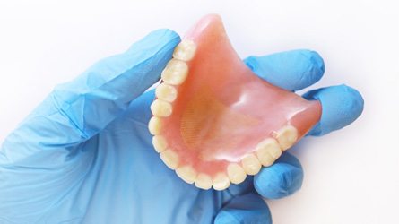 dentist holding full denture