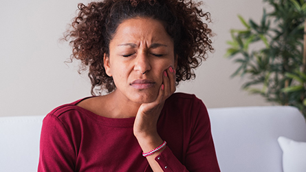 woman holding jaw in pain 