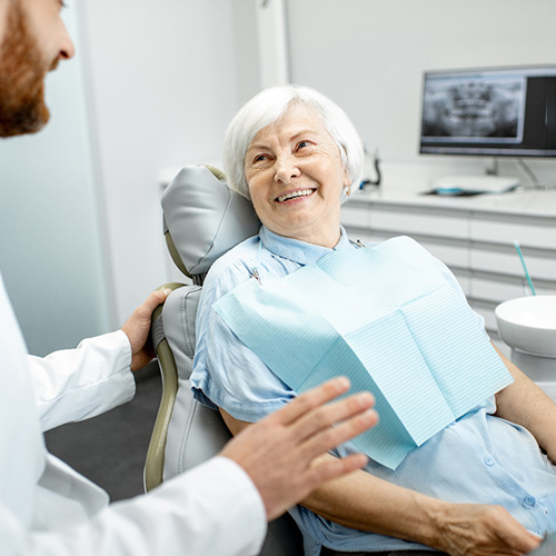 Senior woman smiling at Norton emergency dentist during exam