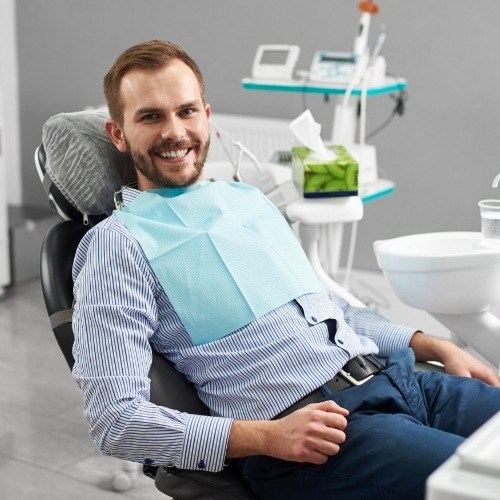 Man smiling in dental office after emergency dentistry