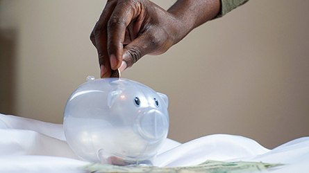 Hand putting coin in piggy bank