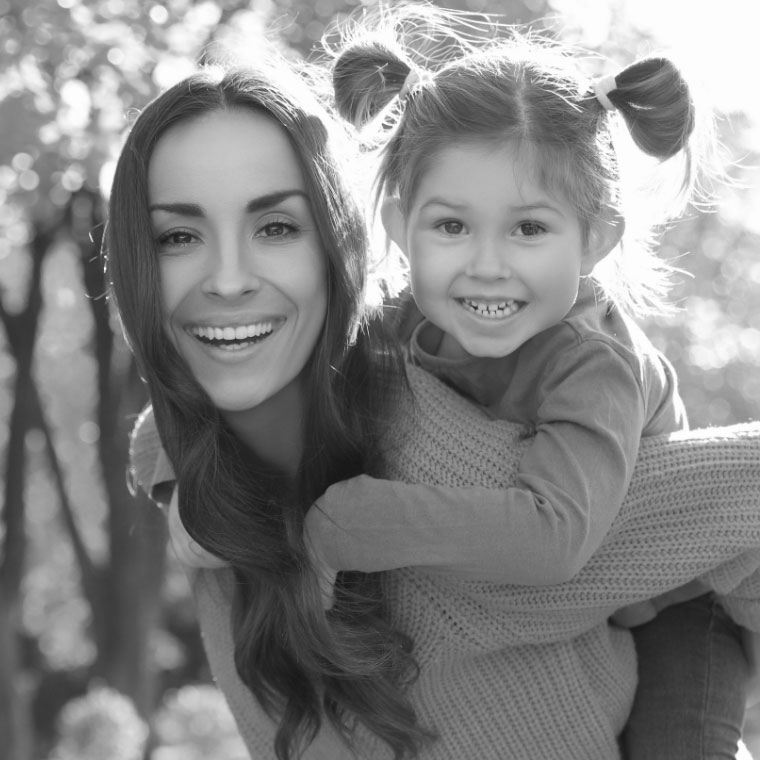 Mother giving her young daughter a piggyback ride