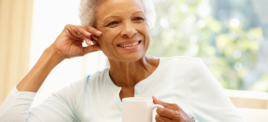 Smiling older woman holding white coffee mug