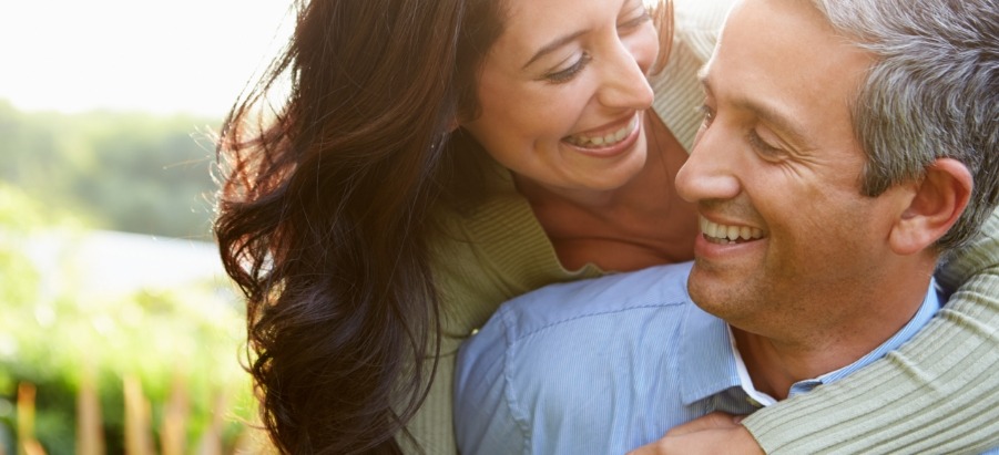 Man and woman holding each other and smiling outdoors