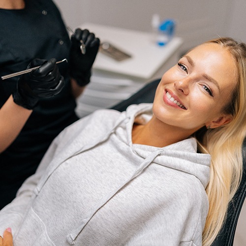 Patient reclined in treatment chair smiling