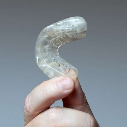 Hand holding a nightguard for bruxism