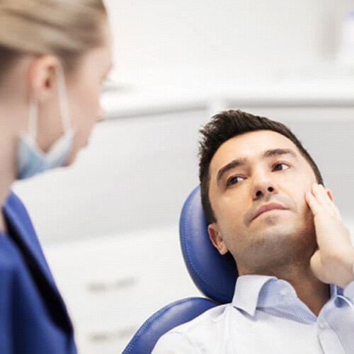 patient explaining his symptoms to dental team member