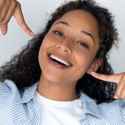 happy, smiling woman pointing at her teeth
