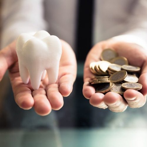 Someone holding a tooth and a pile of coins